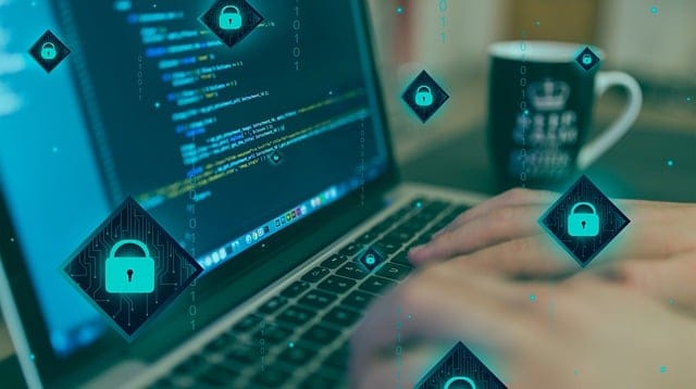 Computer with hands typing and coffee mug in the background. Little lock images overlay the whole image.